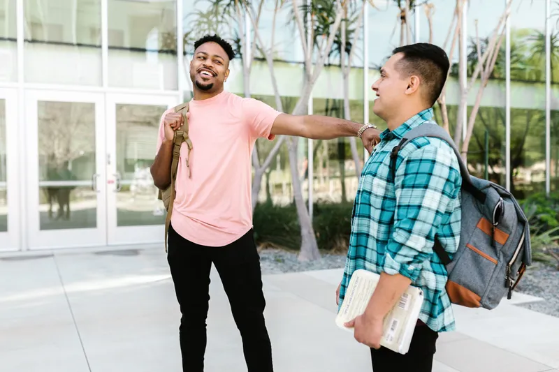 Two students talking on a sunny campus